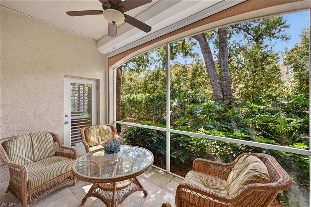 8420 Excalibur Circle, Unit R7 Naples, FL 34108 - Photo 3 of 24 Screened patio featuring a ceiling fan, tiled flooring, and a private view of lush greenery