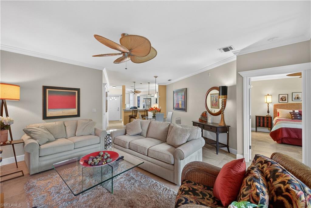 8420 Excalibur Circle, Unit R7 Naples, FL 34108 - Photo 5 of 24 The living area features crown molding, a ceiling fan, and tile flooring, with a visible entryway leading to another room