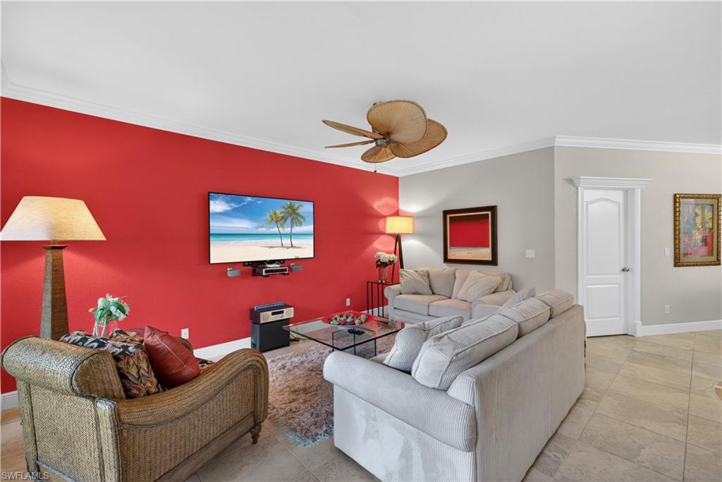 8420 Excalibur Circle, Unit R7 Naples, FL 34108 - Photo 6 of 24 The living area features a bright accent wall, a ceiling fan, and tiled flooring