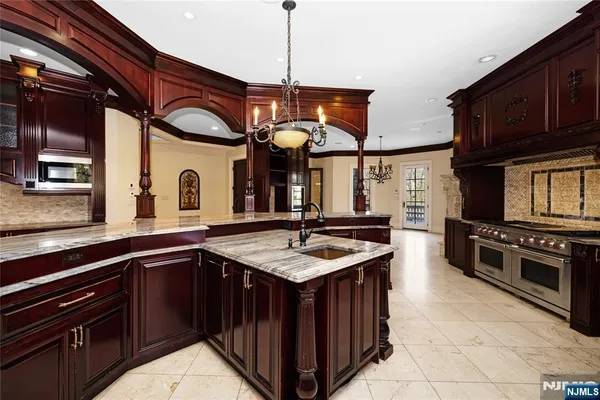 a kitchen with stainless steel appliances granite countertop a sink stove and cabinets