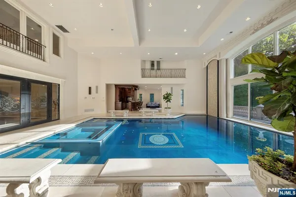 a living room with furniture a flat screen tv and floor to ceiling window