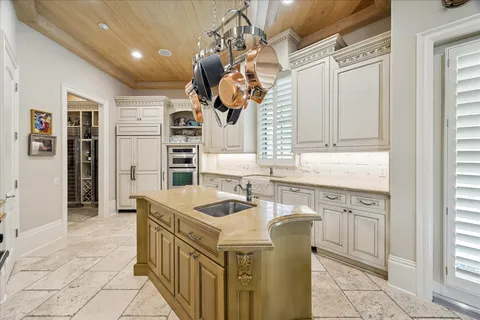 a kitchen that has a sink a microwave oven a stove and white cabinets