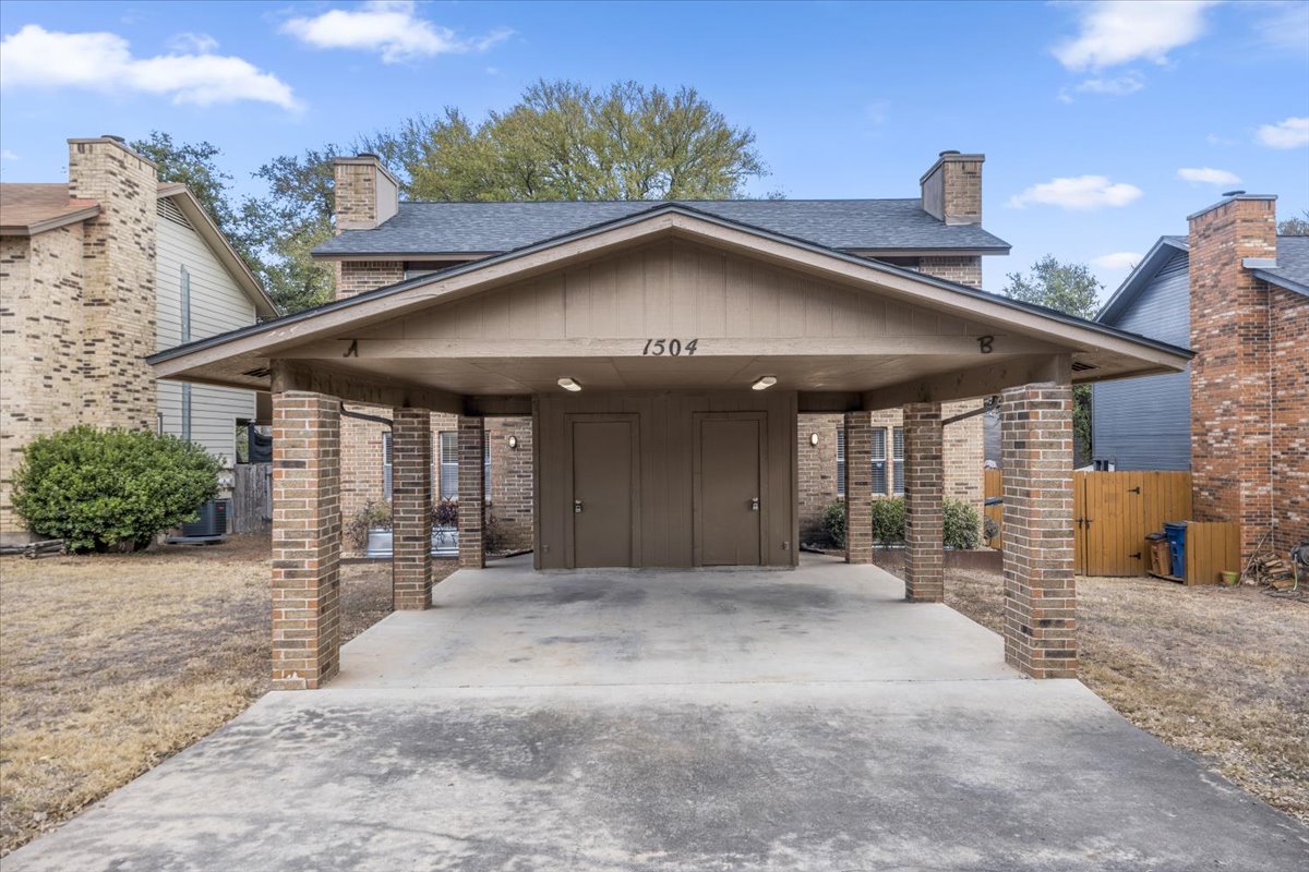 1504 Waterloo Trail, Unit A Austin, TX 78704 - Photo 12 of 12 View of front of property with concrete driveway, covered porch, brick siding, and a gate