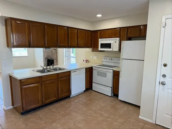 a kitchen with a sink a refrigerator and cabinets