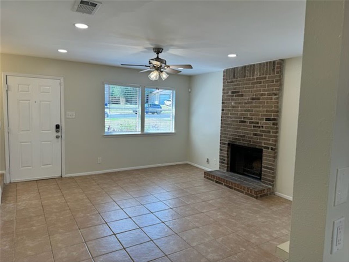 1504 Waterloo Trail, Unit A Austin, TX 78704 - Photo 4 of 12 Unfurnished living room with a brick fireplace, a ceiling fan, light tile patterned flooring, and recessed lighting