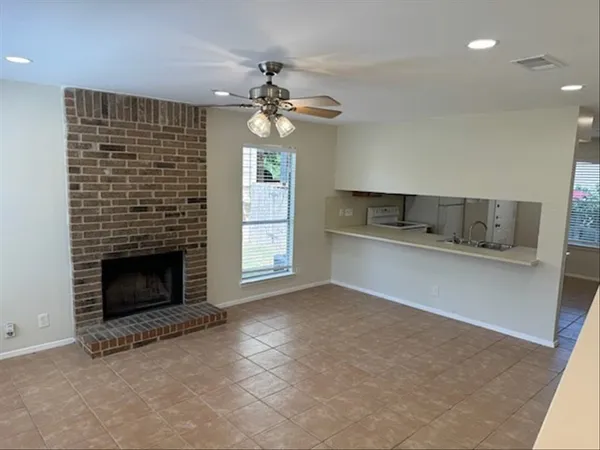 an empty room with windows and fireplace