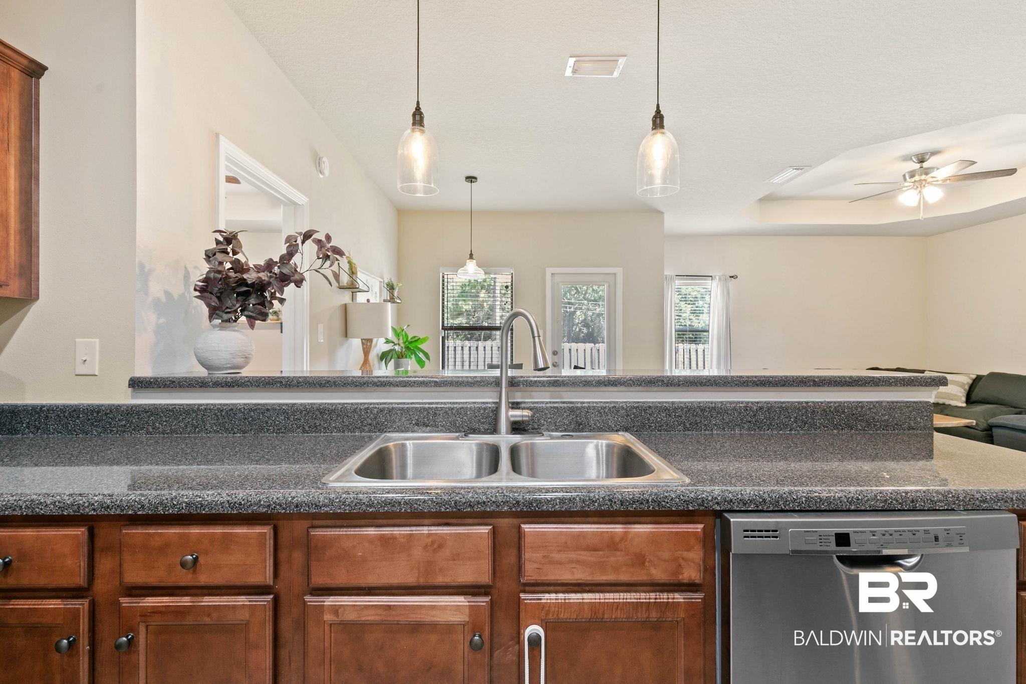 2216 Livingstone Court Mobile, AL 36695 - Photo 16 of 62 Kitchen area featuring a double basin stainless steel sink, a stainless steel dishwasher, speckled countertops, and wood cabinetry