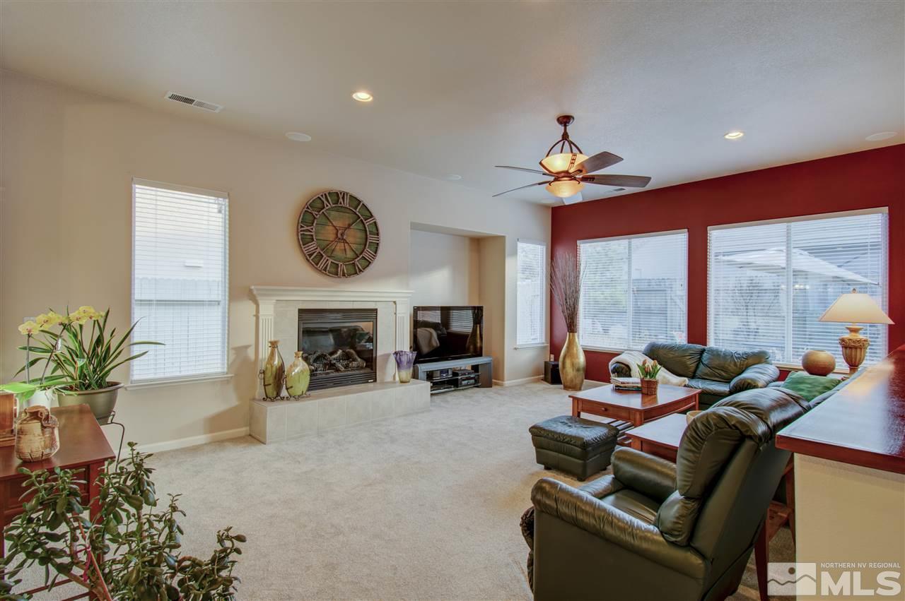 1652 Broadstone Way Reno, NV 89521 - Photo 12 of 25 a living room with furniture a fireplace and a chandelier