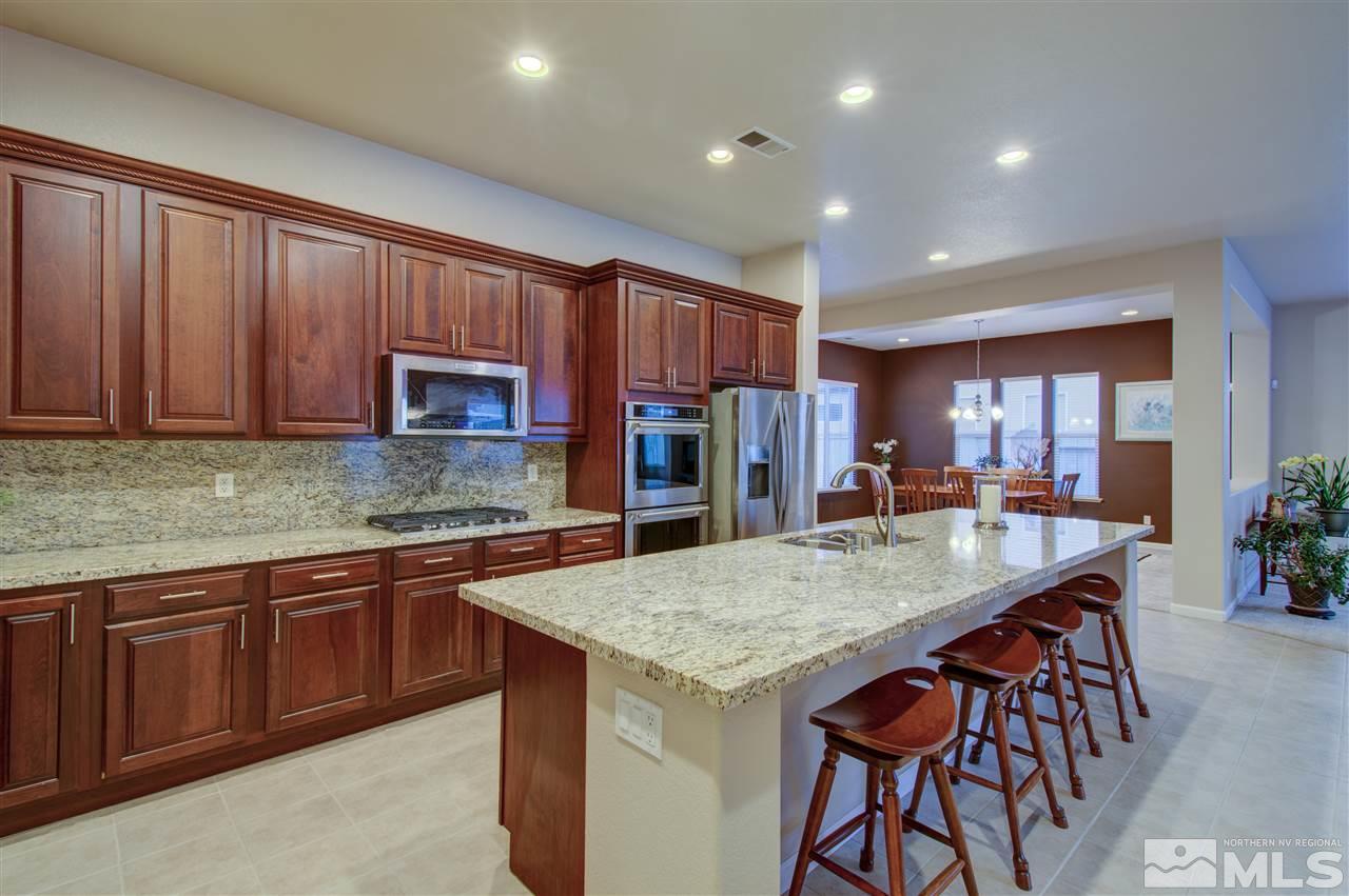1652 Broadstone Way Reno, NV 89521 - Photo 15 of 25 a kitchen with stainless steel appliances granite countertop wooden cabinets a center island and a refrigerator