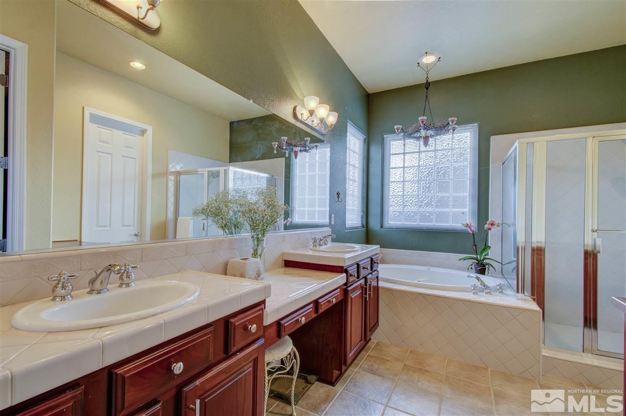 1652 Broadstone Way Reno, NV 89521 - Photo 20 of 25 a bathroom with a sink double vanity granite tub shower and a mirror