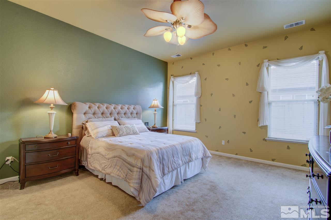 1652 Broadstone Way Reno, NV 89521 - Photo 21 of 25 a bedroom with a bed and a chandelier