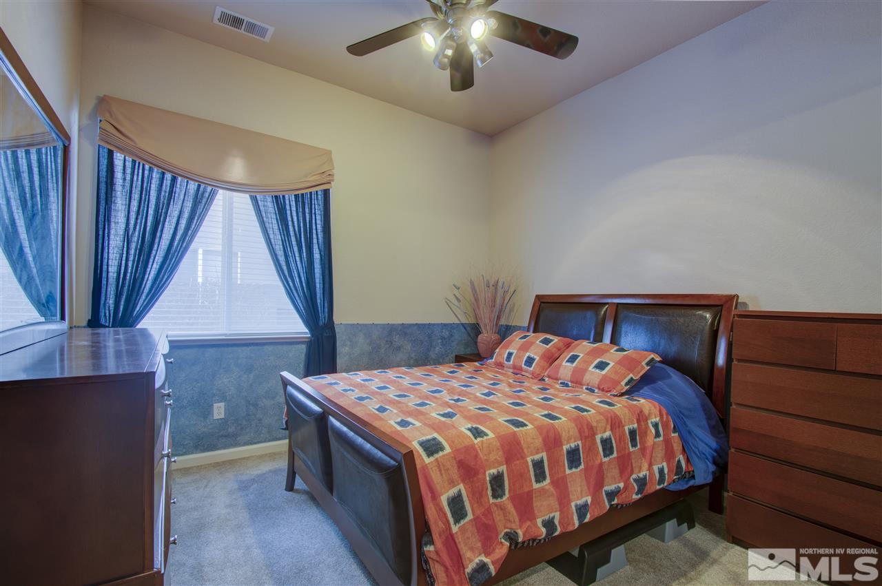 1652 Broadstone Way Reno, NV 89521 - Photo 23 of 25 a bedroom with a bed and a chandelier