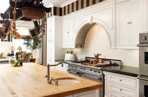 a kitchen with a sink a stove and cabinets