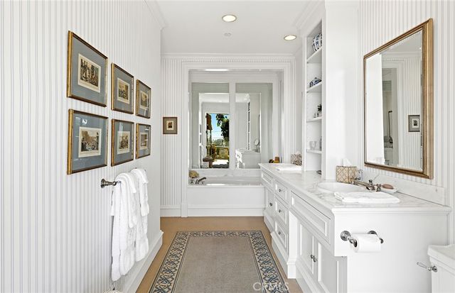 a spacious bathroom with a double vanity sink a mirror and a bathtub