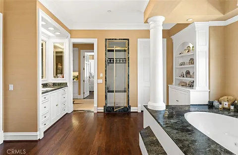 a spacious bathroom with a granite countertop double vanity sink a mirror and a shower