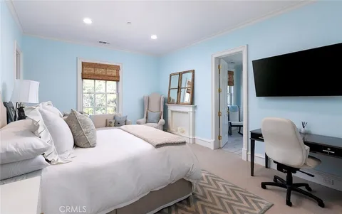 a bedroom with a bed tv and chair