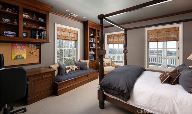 a bedroom with a bed couch and windows