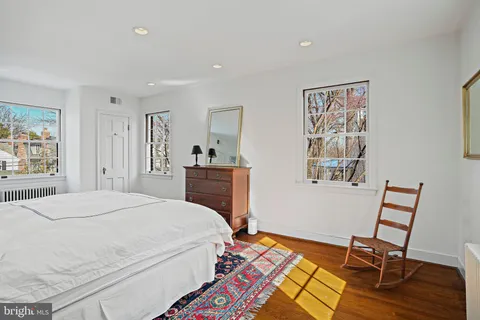 a bedroom with a bed and a table in it with window