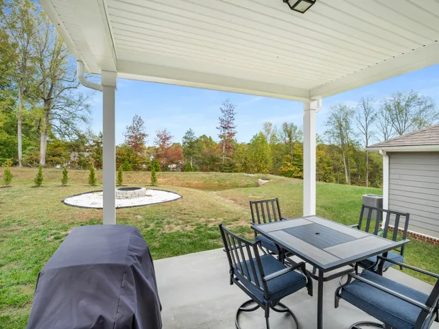 a view of a patio with a table chairs and a backyard