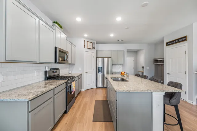 a kitchen with granite countertop a sink stove and refrigerator