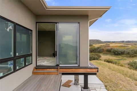a view of a balcony with floor to ceiling windows with wooden floor