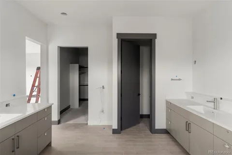 a bathroom with a double vanity sink and mirror with bathtub