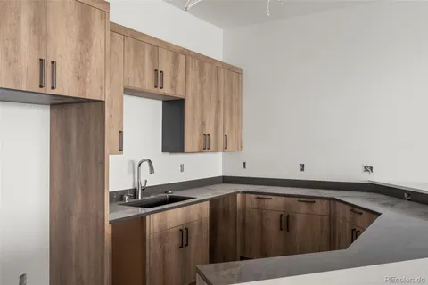 a kitchen with granite countertop a sink cabinets and stainless steel appliances