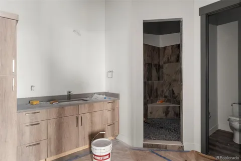 a bathroom with a granite countertop sink toilet and shower