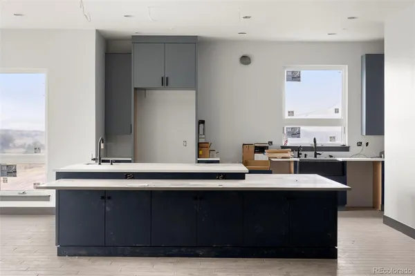 a living room with stainless steel appliances kitchen island granite countertop a sink dishwasher a stove and a refrigerator with wooden floor