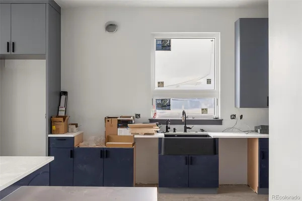 a kitchen with a sink a stove cabinets and wooden floor