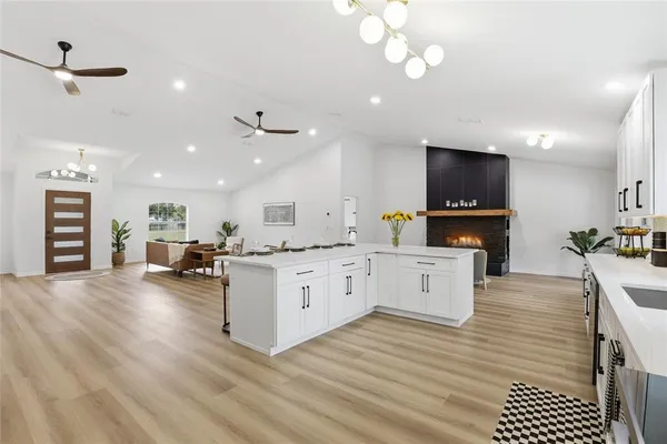 a large white kitchen with sink and cabinets