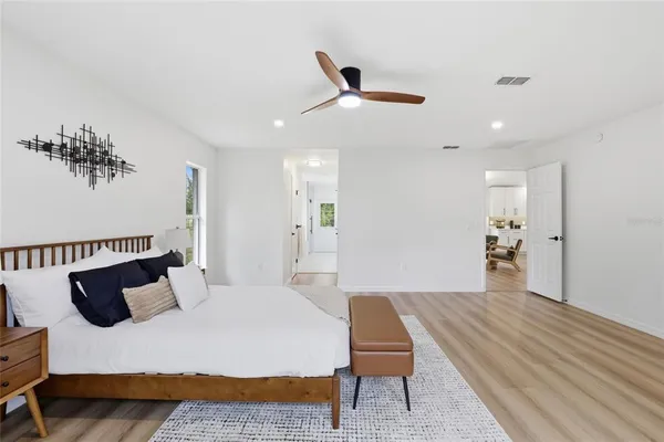 a spacious bedroom with a bed and a dresser