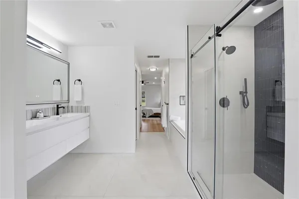 a bathroom with a bathtub shower sink and mirror