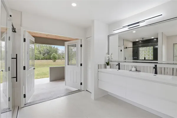 a large white bathroom with a large mirror shower and sink
