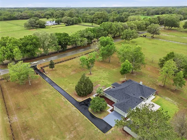 an aerial view of residential houses with outdoor space and river
