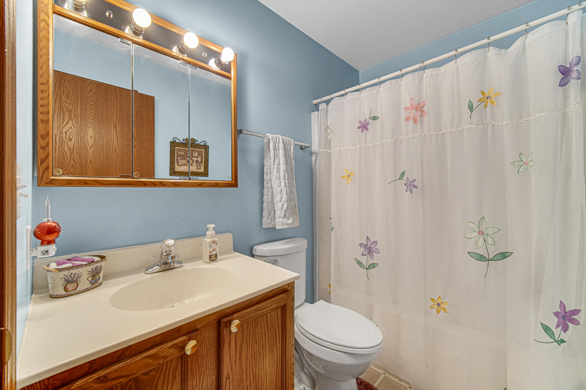 8613 Van Buren Street Merrillville, IN 46410 - Photo 14 of 18 a bathroom with a sink a toilet and shower curtain