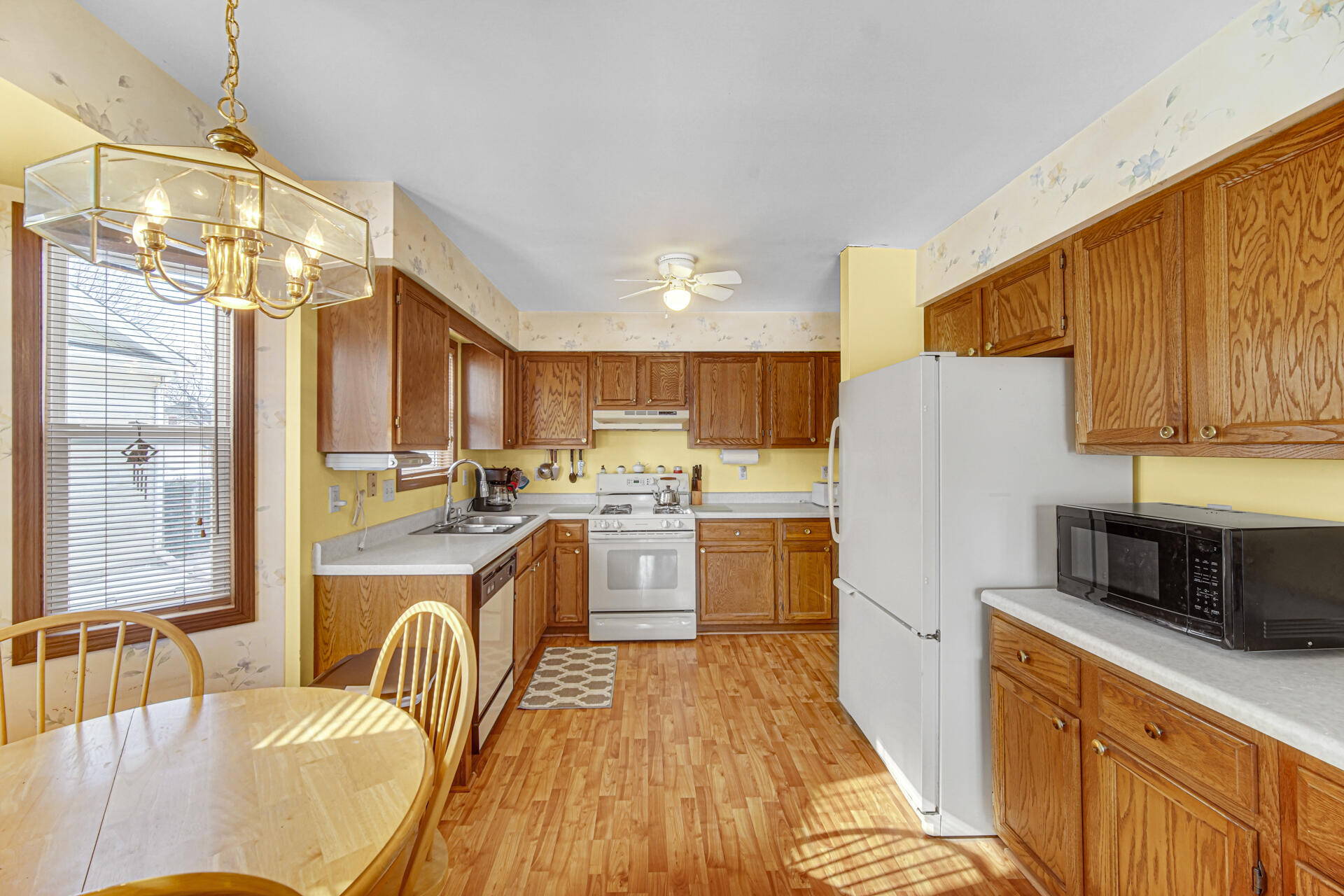 8613 Van Buren Street Merrillville, IN 46410 - Photo 6 of 18 a kitchen with a refrigerator a stove top oven a sink dishwasher and wooden cabinets