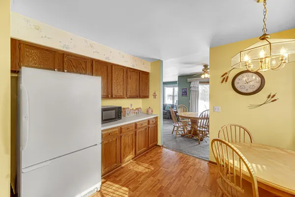 a kitchen with stainless steel appliances granite countertop a refrigerator a stove and a sink with wooden floor