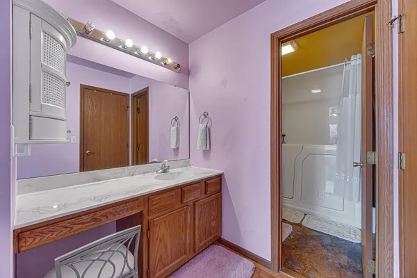 a spacious bathroom with a granite countertop sink and a mirror