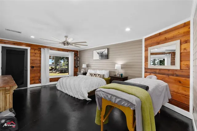 a bedroom with two beds and a large mirror next to a window