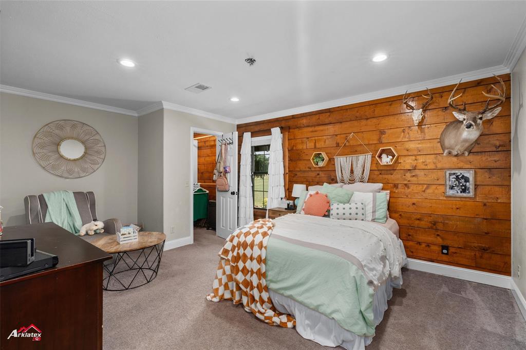 10073 Ferry Lake Road Oil City, LA 71061 - Photo 23 of 39 a bedroom with a large bed and a chandelier