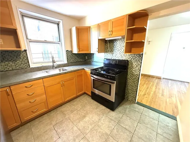 a kitchen with granite countertop a stove a sink and a microwave