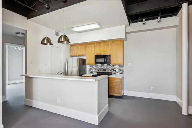 a kitchen with stainless steel appliances a refrigerator and a stove top oven