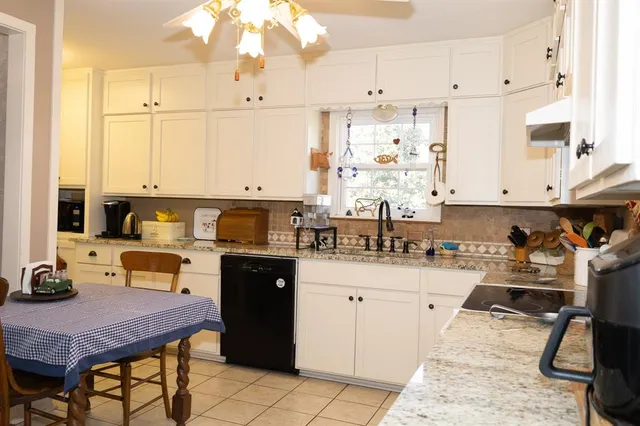 a kitchen with a sink stove and white cabinets