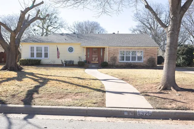 a front view of house with yard covered in snow