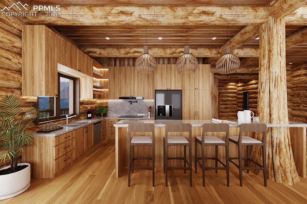 9297 Chipita Park Road Cascade, CO 80809 - Photo 10 of 25 a kitchen with stainless steel appliances a table chairs and a wooden floors