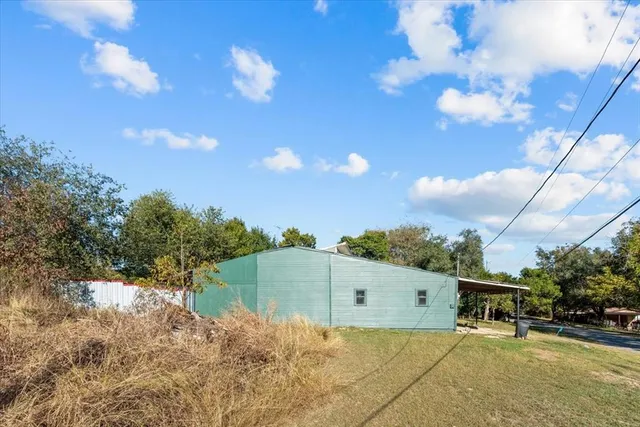 a backyard of a house with table and chairs