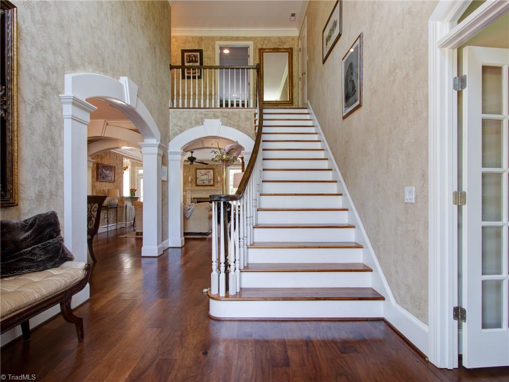 8404 Oakchester Court Oak Ridge, NC 27310 - Photo 4 of 30 Open foyer with walnut wood flooring, heavy detailed molding and stucco finished walls.