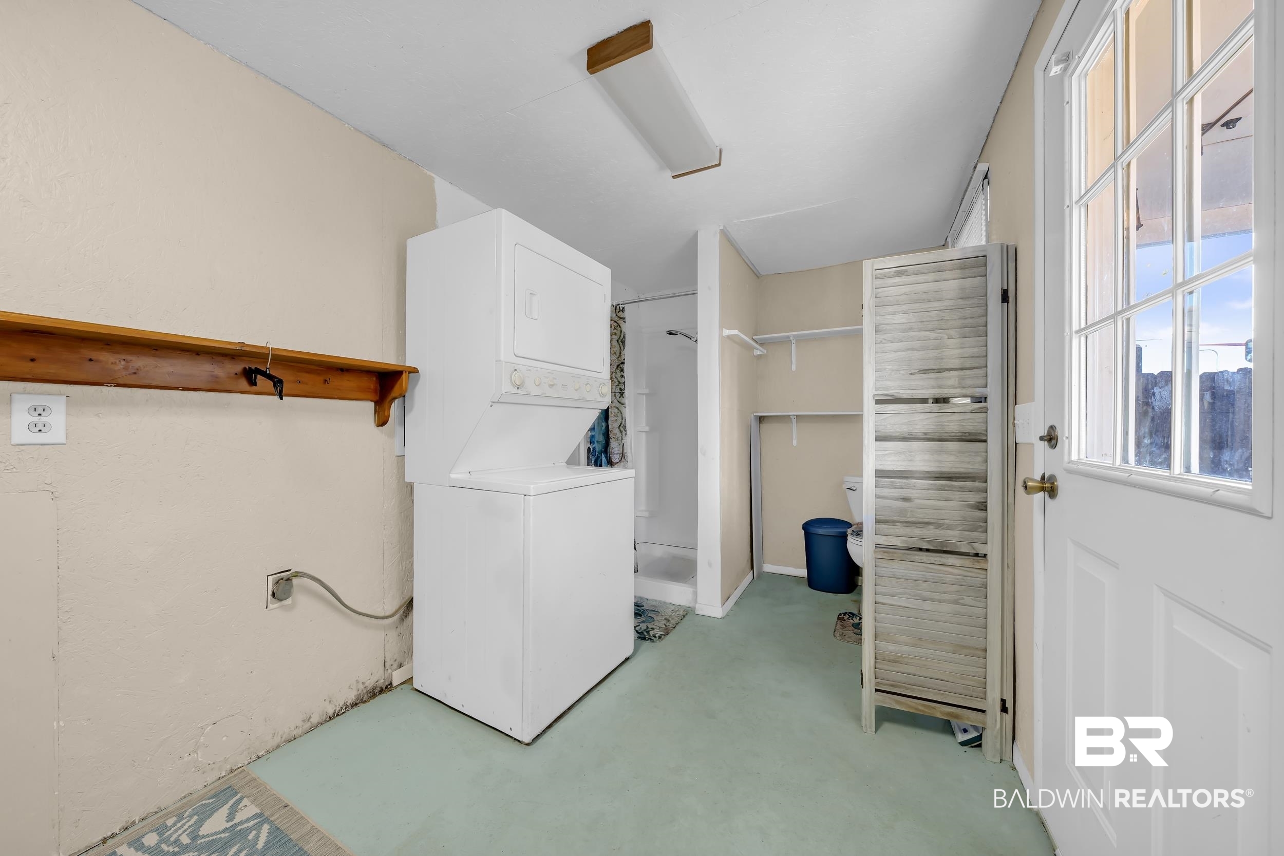 182 Defuniak Loop Lillian, AL 36549 - Photo 12 of 21 Laundry room featuring stacked washer and dryer and concrete flooring