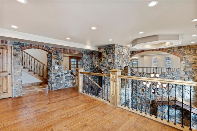246 Woods Creek Road Morgan, UT 84050 - Photo 36 of 69 Hardwood flooring throughout, stone-clad walls, brick archways, recessed lighting, and a custom wood and wrought iron staircase railing